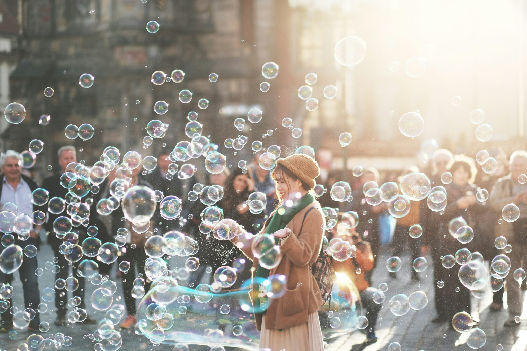 Group Of Humans, Healthspan Image, An asian woman blowing bubbles in a busy street